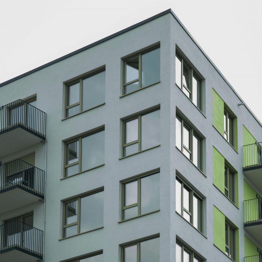 Contemporary architecture of a modern apartment complex with visible balconies and colorful accents.