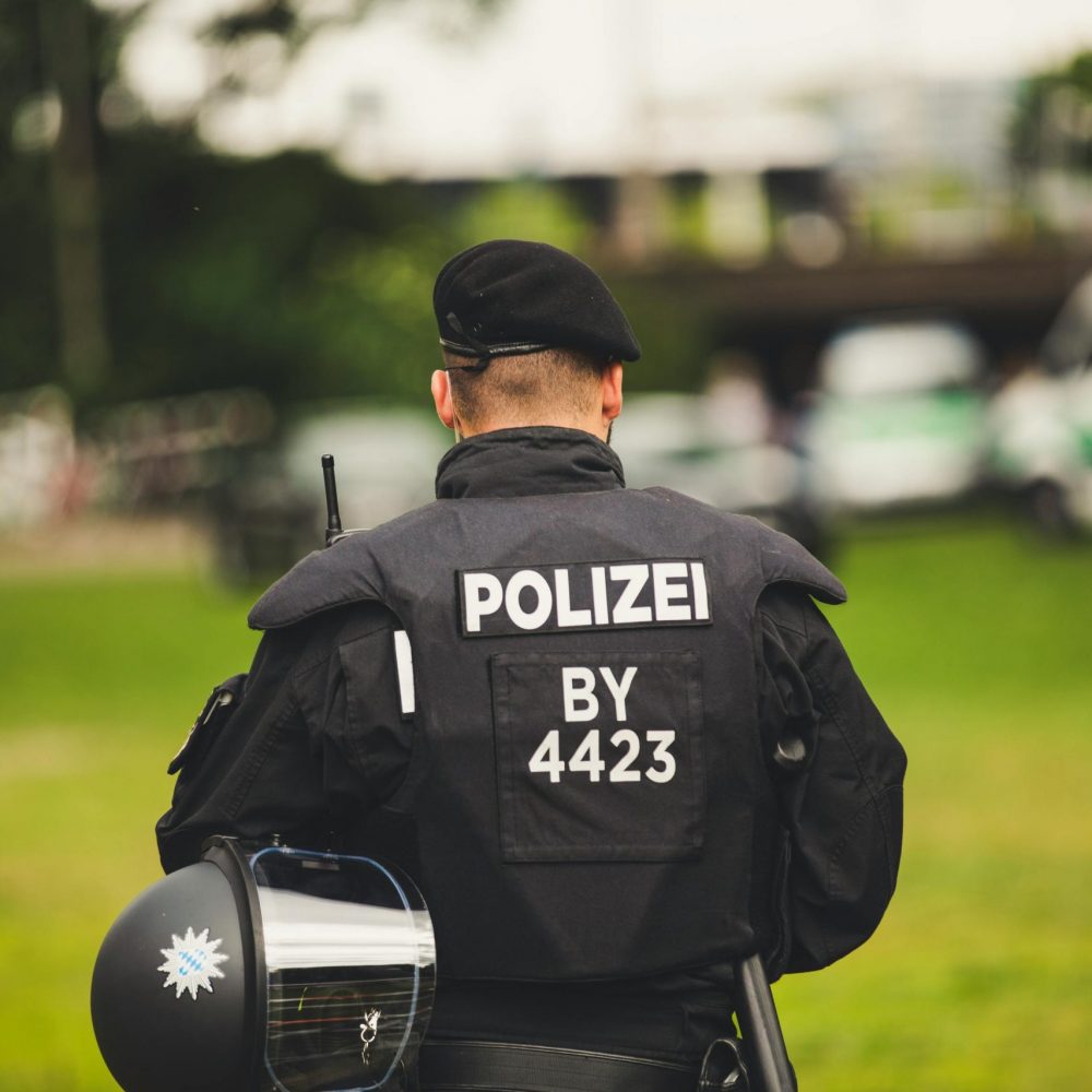 A police officer stands in uniform outdoors, highlighting law enforcement.